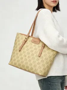 Vista detallada del bolso tote con estampado M y ribete de cuero marrón en modelo