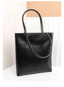 Detailed view of black oil wax leather tote bag with elegant wrinkled texture and long straps