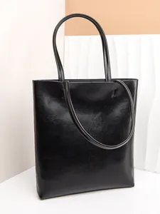 Minimalist black oil wax leather tote bag with glossy finish and slim shoulder straps