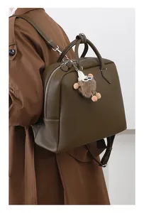 Dettaglio della borsa tote in pelle martellata verde oliva con ciondolo in peluche