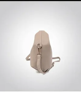 Detail view of beige lychee leather bag with gold hardware and side contour profile