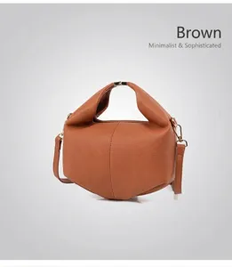 Detail of brown lychee grain leather handbag featuring gold buckles and detachable strap