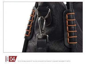 Detail of detachable shoulder strap with silver metal hook on black pebble leather bag