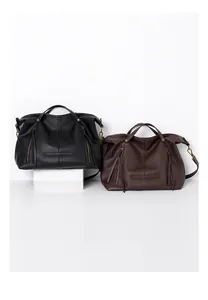 Detail view of large leather tote bags with vertical fringe zippers and adjustable straps
