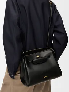 Elegante bolso tote de cuero negro con herrajes dorados y logotipo, visto desde la parte trasera