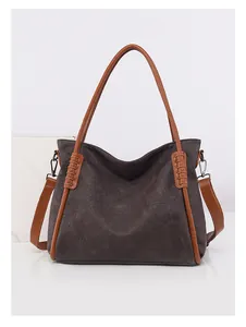 Detail of vintage brown leather tote bag with contrast trim and crossbody strap attachment
