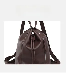 Detail view of coffee leather backpack with drawstring closure and metal eyelets