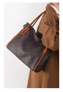 Detailed view of dark brown tote bag with vintage leather texture and handmade stitching