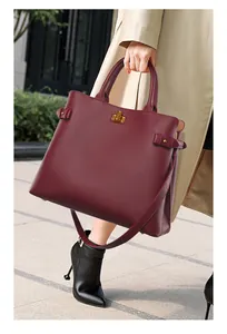 Close-up of a burgundy leather tote bag with gold buckle and pebble grain texture