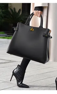 Close-up of premium black leather tote with gold turn-lock buckle and detailed grain