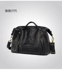 Detail view of black pebbled leather tote bag with dual vertical zippers and sturdy handles