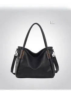 Detail showing high-quality black pebble leather texture and woven shoulder strap accents