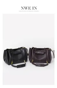 Detalle de bolsos tote grandes de cuero negro y granate con elegantes herrajes dorados