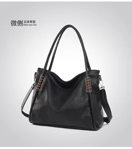 Close-up of black tote bag with lychee grain texture and contrast brown stitching
