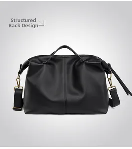 Rear view of black pebble leather tote bag showing bronze metal clasp and stitching