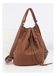 Macro detail of brown lychee grain leather texture and adjustable strap on backpack