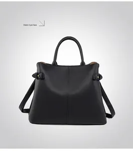Rear view of black lychee grain leather tote bag with gold rivets and side buckles