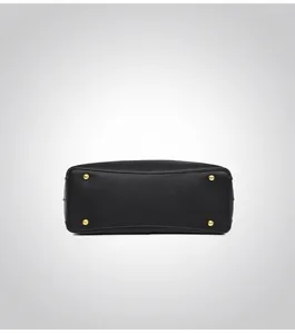 Detail view of the black leather handbag base with four protective gold metal studs