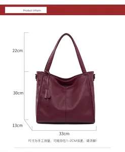Detailed view of burgundy tote bag showing soft pebble leather texture and tassel detail