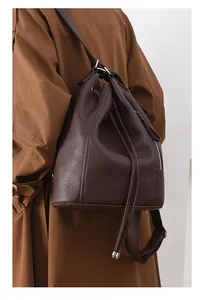 Detail of dark brown pebble leather backpack with drawstring closure and metal zipper side