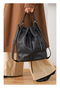 Detail of black pebbled leather drawstring backpack with silver side zipper and large capacity