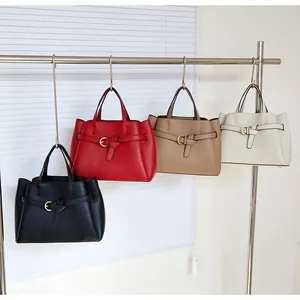 Detailed close-up of textured leather handbags in four colors hanging on a rack