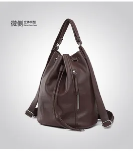 Detail of dark brown pebble leather backpack showing drawstring and metallic zipper