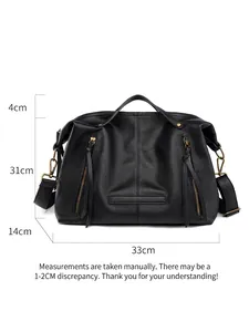 Large black faux leather tote bag with side zippers and detachable nylon strap