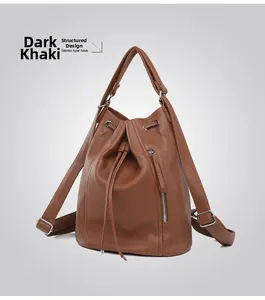 Detail view of deep khaki leather bucket backpack with drawstring and pebble texture
