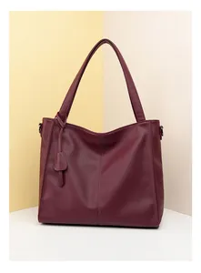 Detail of burgundy lychee grain leather tote bag with elegant vertical stitching
