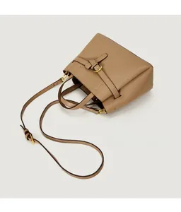 Detail of tan leather tote bag with decorative belt buckle and adjustable shoulder strap