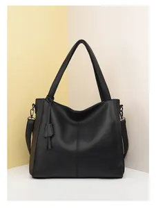 Close-up of black leather tote bag with lychee texture and silver metal buckle details