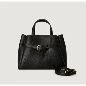 Close-up of black lychee grain leather handbag with gold horseshoe buckle and strap