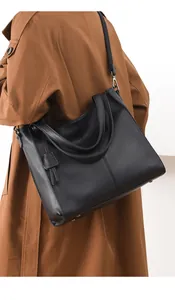 Detail of black pebbled leather tote bag with silver hardware and adjustable strap