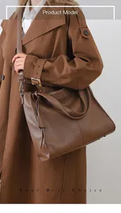 Brown lychee texture leather tote bag with elegant tassel and crossbody strap detail