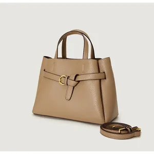 Detail of lychee pattern leather tote bag with gold metal buckle and sturdy handles