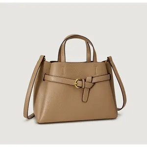 Detail of khaki pebbled leather handbag with metal buckle and detachable shoulder strap
