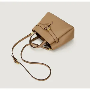 Detailed macro view of brown pebbled leather texture with a gold-tone metal buckle