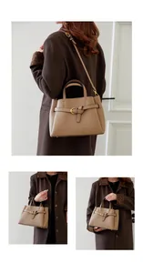 Detail of khaki leather texture and golden hardware on minimalist tote handbag