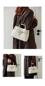 Detail of off-white lychee texture leather handbag with gold buckle and crossbody strap