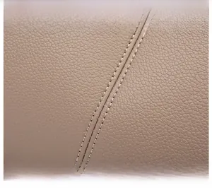 Detailed close-up of apricot leather texture with precise double-stitching craftsmanship