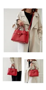 Detail of red lychee pattern handbag featuring gold buckle and adjustable strap