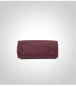 Macro view of burgundy leather tote bottom with protective silver metal feet studs