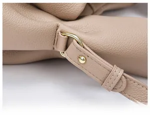 Detail of durable gold-tone D-ring hardware on a lychee-patterned leather handbag strap