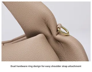 Detail of golden hardware D-ring on lychee grain leather handbag for strap attachment