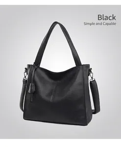 Detail of black pebbled leather tote bag with sturdy handles and metal strap hooks