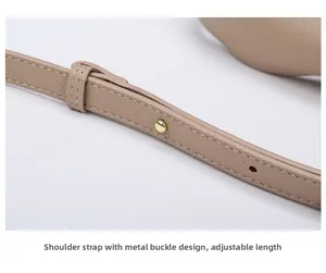 Detail of adjustable leather shoulder strap with golden metal snap and lychee pattern