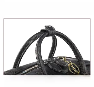 Dettaglio borsa in pelle nera con cuciture bianche a contrasto e finiture dorate