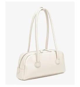 Detalle del bolso de hombro rectangular de cuero crema con doble cremallera y textura fina