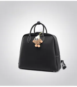 Dettaglio della borsa in pelle nera con trama litchi e ciondolo a forma di mostro